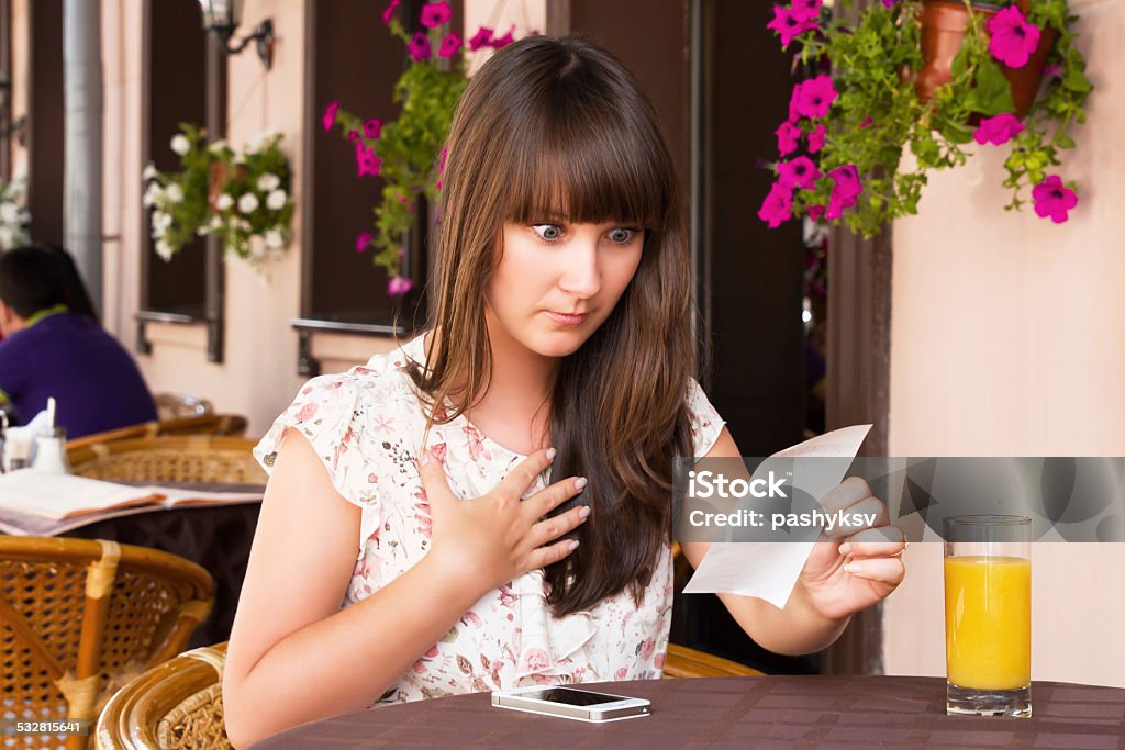 Woman unhappy amount of the invoice Woman shocked by the amount of the invoice Restaurant Stock Photo