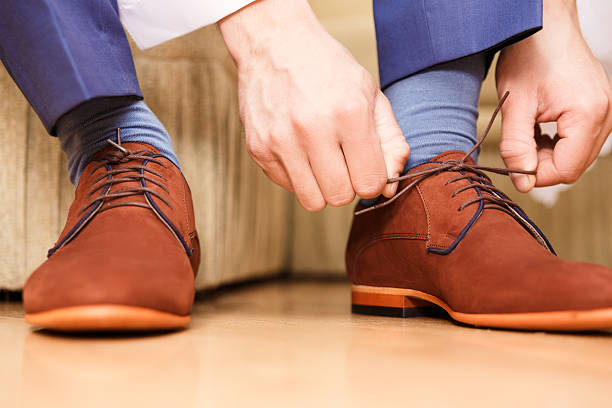 istock groom putting his wedding shoes. 532815887
