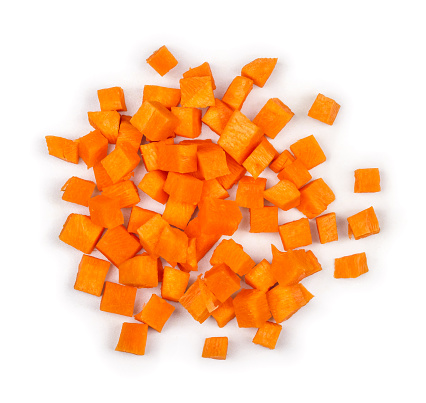 cut into squares pieces of carrot on a white background