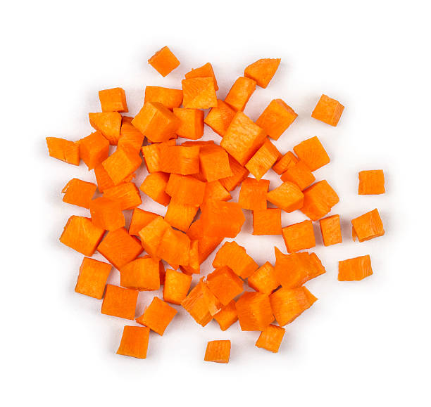 cut into squares pieces of carrot on a white background cut into squares pieces of carrot on a white background carrot isolated vegetable nobody stock pictures, royalty-free photos & images