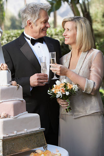 istock Middle-aged couple toasting near wedding cake, portrait 532817509
