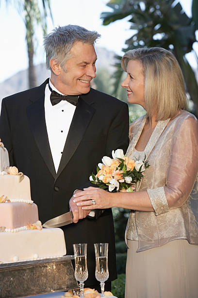 istock Middle-aged couple cutting wedding cake, portrait 532817515