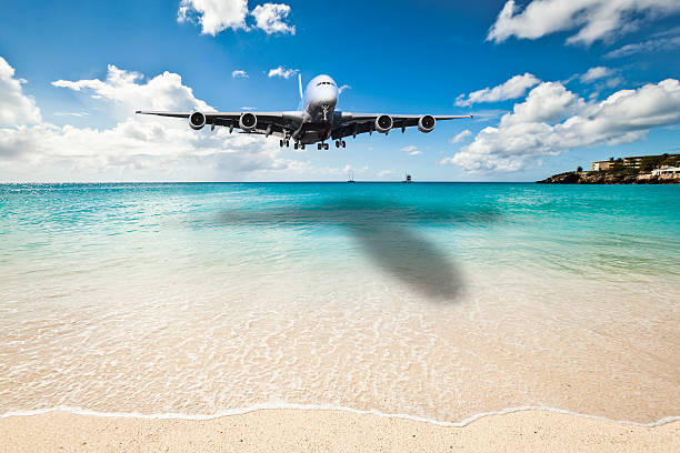 Air Travel Aircraft landing at Princess Juliana International Airport over Maho Beach in Netherlands Antilles. saint martin caribbean stock pictures, royalty-free photos & images