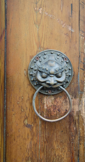 ancient wooden gate with two door knocker rings close-up