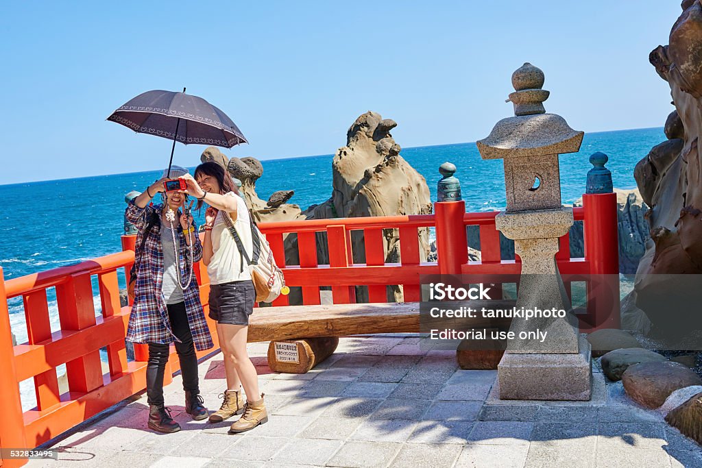 Selfie Nichinan, Japan - September 26, 2014: two japanese girls take a selfie with Sea of Hyuga as background. One of the girl is holding a parasol. Miyazaki Prefecture Stock Photo