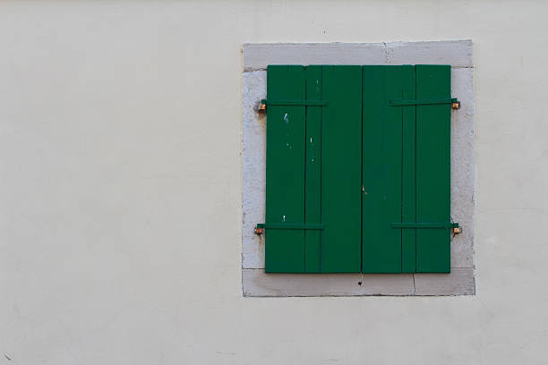 istock Window closed green shutters on the wall 532833837