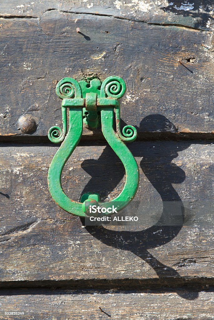 Antique brass door knocker on a wooden door. Antique brass door knocker on a wooden door, vertical 2015 Stock Photo