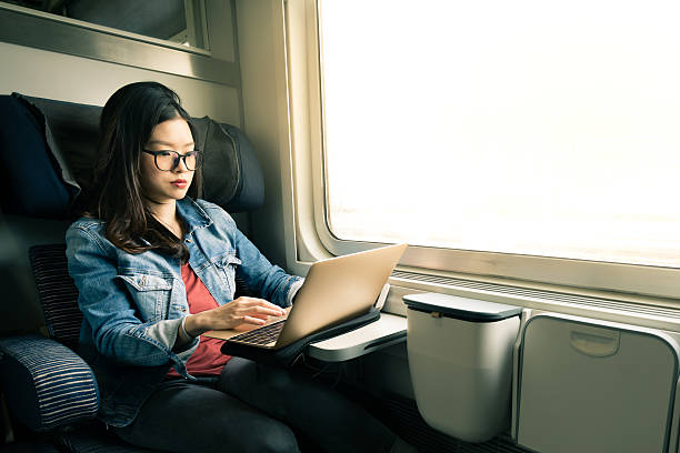 アジア女性のラップトップで仕事に、鉄道、ビジネストラベルの概念 - female mobility blank teenage girls ストックフォトと画像