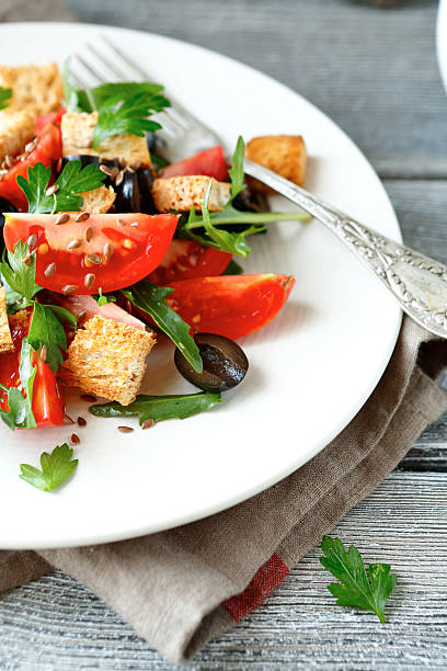 istock salad with tomatoes and croutons on a white plate 532849081