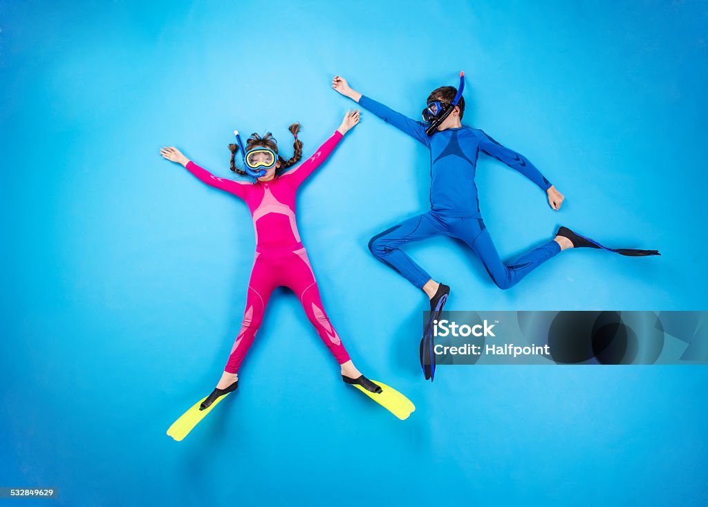 Child scuba divers Children scuba diving deep in the sea. Studio shot on a blue background. Child Stock Photo