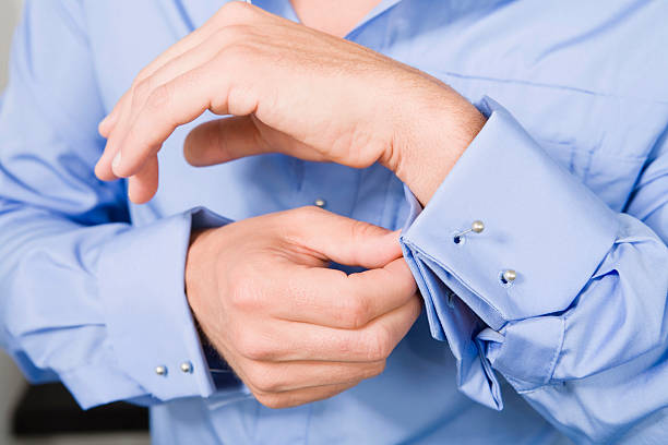 istock Man fastening cufflinks mid section close-up 532849661