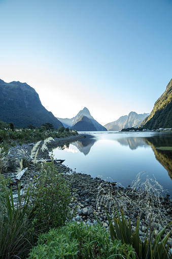Sunset view at Milford Sound with reflection of the Mitre Peak mountains on the calm lake, South Island, New Zealand.
