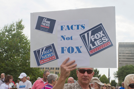 Asheville, North Carolina, USA - August 4, 2014:  A man holds up a sign saying that Fox News Lies and makes things up at a Moral Monday rally on August 4, 2014 in downtown Asheville, NC