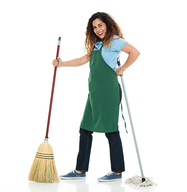 istock Cheerful female janitor holding broom and mop 532851024