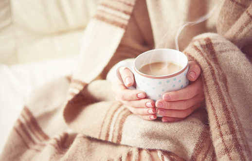 cup of hot coffee warming in the hands of girl