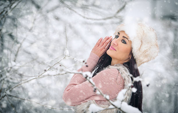 istock Woman with white fur cap smiling enjoying the winter scenery 532852513