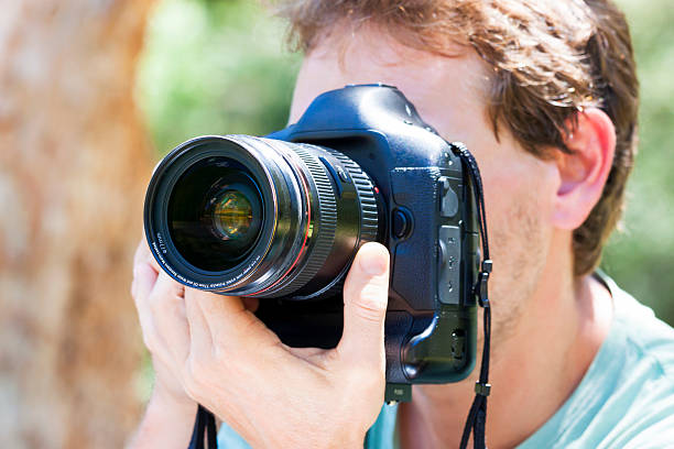 istock CLoseup male Photographer holding DSLR camera 532852823