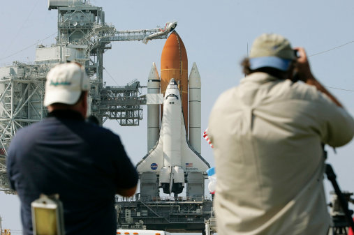 CAPE CANAVERAL, FL - JULY 25:  Journalists document the rollback of the rotating service structure, which surrounded Space Shuttle Discovery, at Kennedy Space Center July 25, 2005 in Cape Canaveral, Florida. Discovery is scheduled for launch July 26 and will be the first shuttle launch since the Columbia disaster over two years ago.  (Photo by Win McNamee/Getty Images)