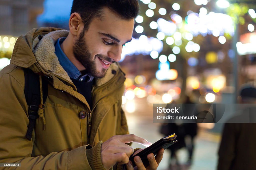 Portrait of young man using his mobile phone at night. Outdoor portrait of young man using his mobile phone at night. 2015 Stock Photo