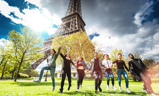 Group of people jumping on the park under the tour eiffel