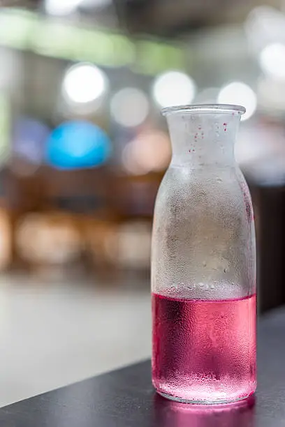 A bottle of Thai's Uthaithip (pink herbal) drink with blurred background. A traditional herbal drink in summer for Thai people