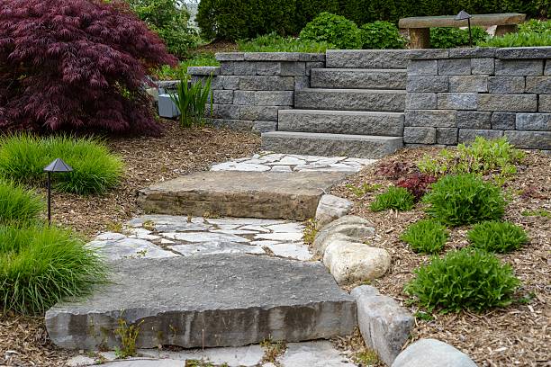 профессиональные ландшафта с асфальтоукладчики и валунов - retaining wall flower bed ornamental garden landscaped стоковые фото и изображения