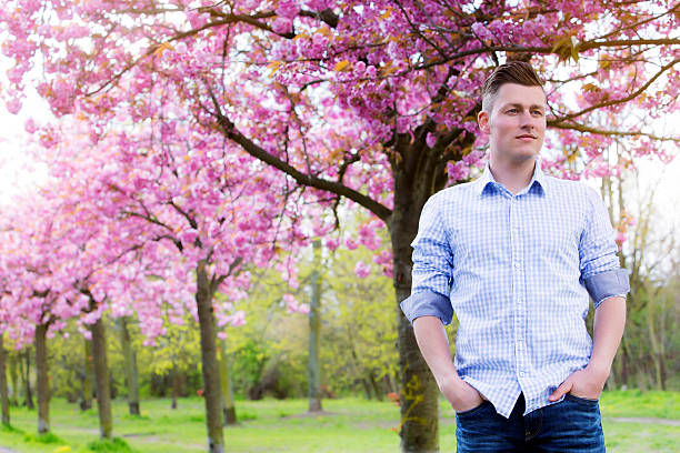 istock portrait of man outdoors with cherry blossom 532858526