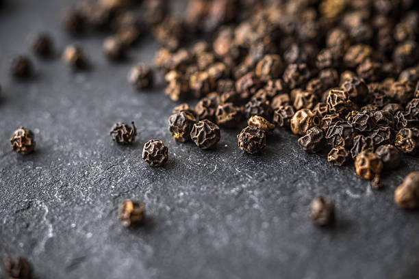 istock Large black pepper peas on black stone 532859112