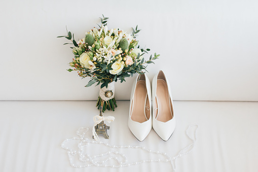 Wedding accessories: shoes and bouquet of the bride