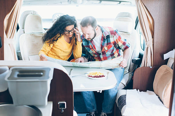 istock Young couple looking at map inside of caravan 532863080
