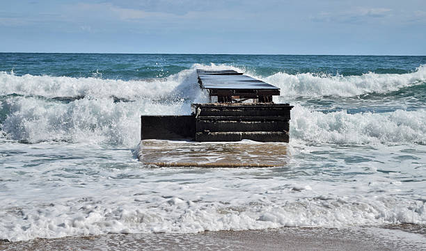 mare e onde che sciabordano sulla dock - wave sea storm water foto e immagini stock