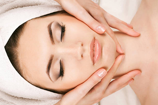 istock Young woman doing facial massage 532873600