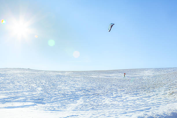 Snowkiting on a frozen lake - winter extreme sport in Trentino Italy