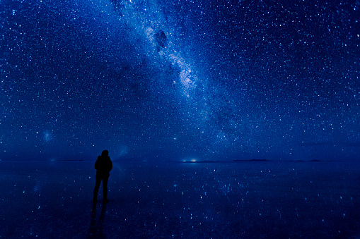 Milkyway and stars reflected on the surface of the water at Uyuni in Bolivia. Standing in the middle of galaxy.