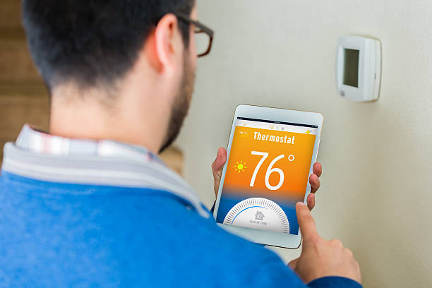 istock Homeowner uses digital table to control thermostat in his home 532880108