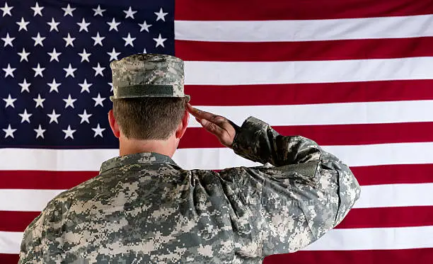 Photo of Veteran male solider saluting the flag of USA