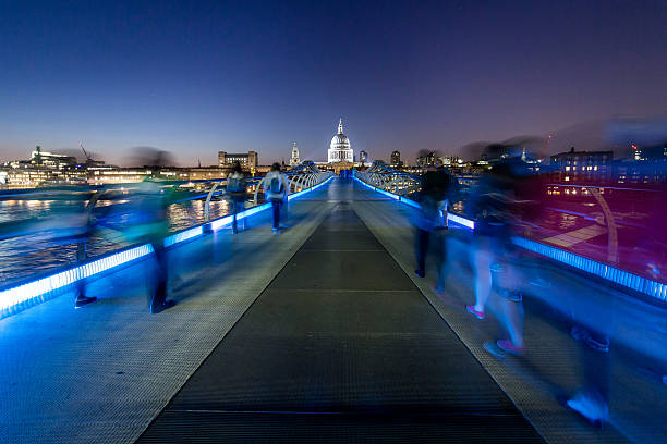 Saint Paul's Cathedral and tourists walking on Millenium Bridge night