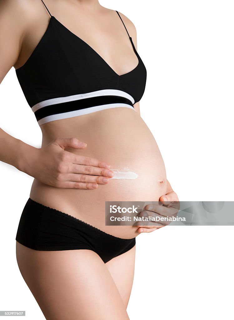 Healthy pregnancy Pregnant woman skin care moisturizer cream on belly 2015 Stock Photo