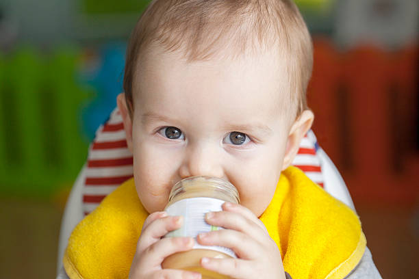 Baby boy eating by himself stock photo