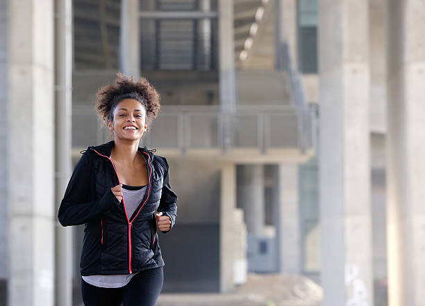 istock Smiling young woman running outside 532920351