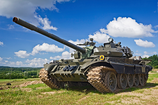 Old Russian tank T-55 on the battle field against blue sky