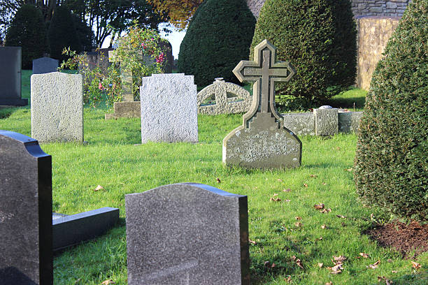 istock Neglected RIP gravestones / granite cross, church graveyard cemetery, leaning / falling-over 532936045