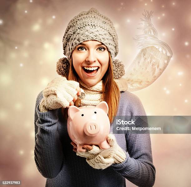 Happy Young Woman Depositing Money Into Her Piggy Bank Stock Photo - Download Image Now
