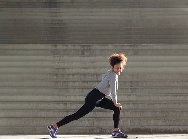 istock Smiling young woman stretching leg muscles 532938335
