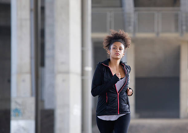 istock Active young woman jogging in urban environment 532939735