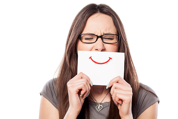 istock Crying young woman with smile painted on paper 532939831