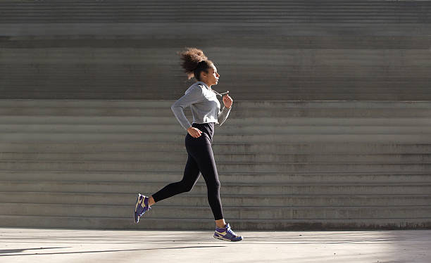 istock Young woman running by stairs 532940461