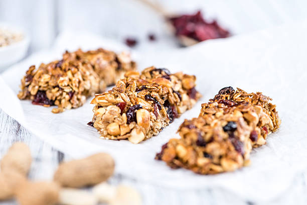 Homemade Granola Bars with Peanuts and Cranberries (selective fo Homemade Granola Bars with Peanuts and Cranberries (selective focus) as detailed close-up shot homemade stock pictures, royalty-free photos & images