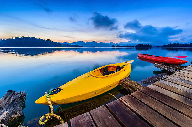 istock Canoe floating on the calm water under amazing sunrise 532949790