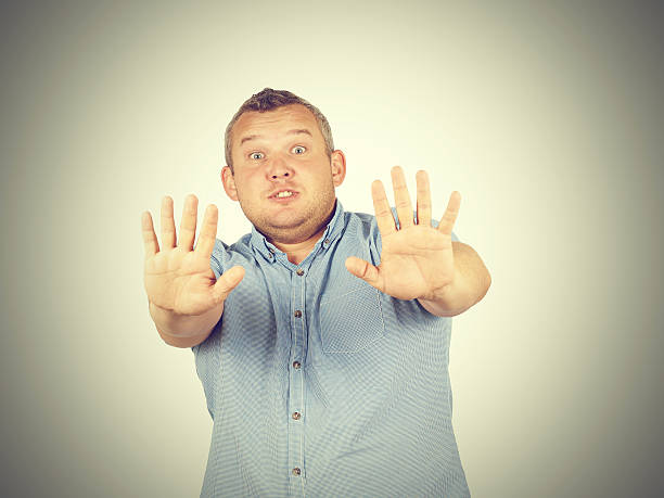 istock Fat man looking shocked scared trying to protect himself 532951370